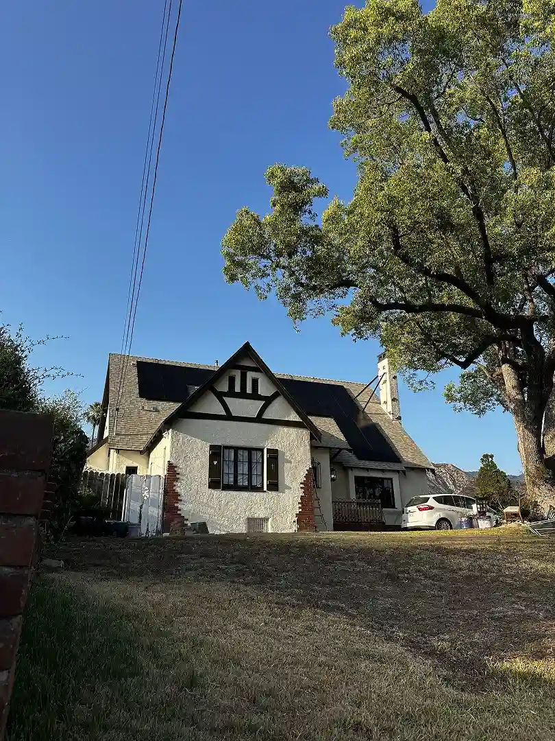 Tudor-style Altadena home with rooftop solar installation visible above the dormers