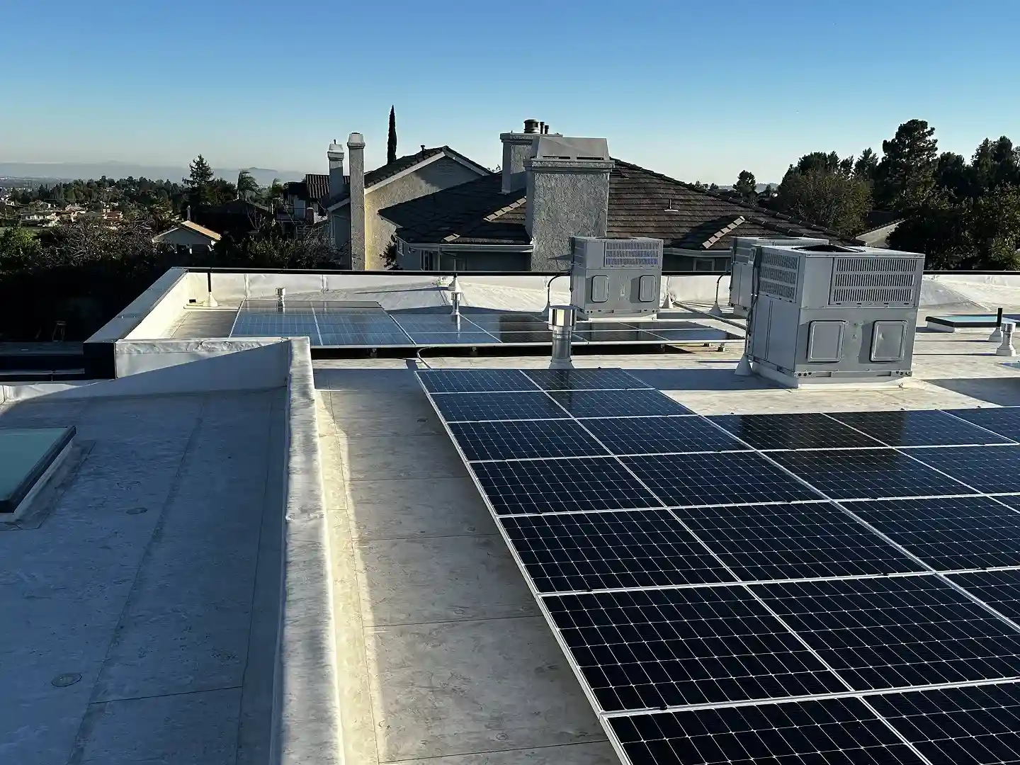 13.8 kW residential solar installation on flat roof with San Gabriel mountain views, Porter Ranch CA