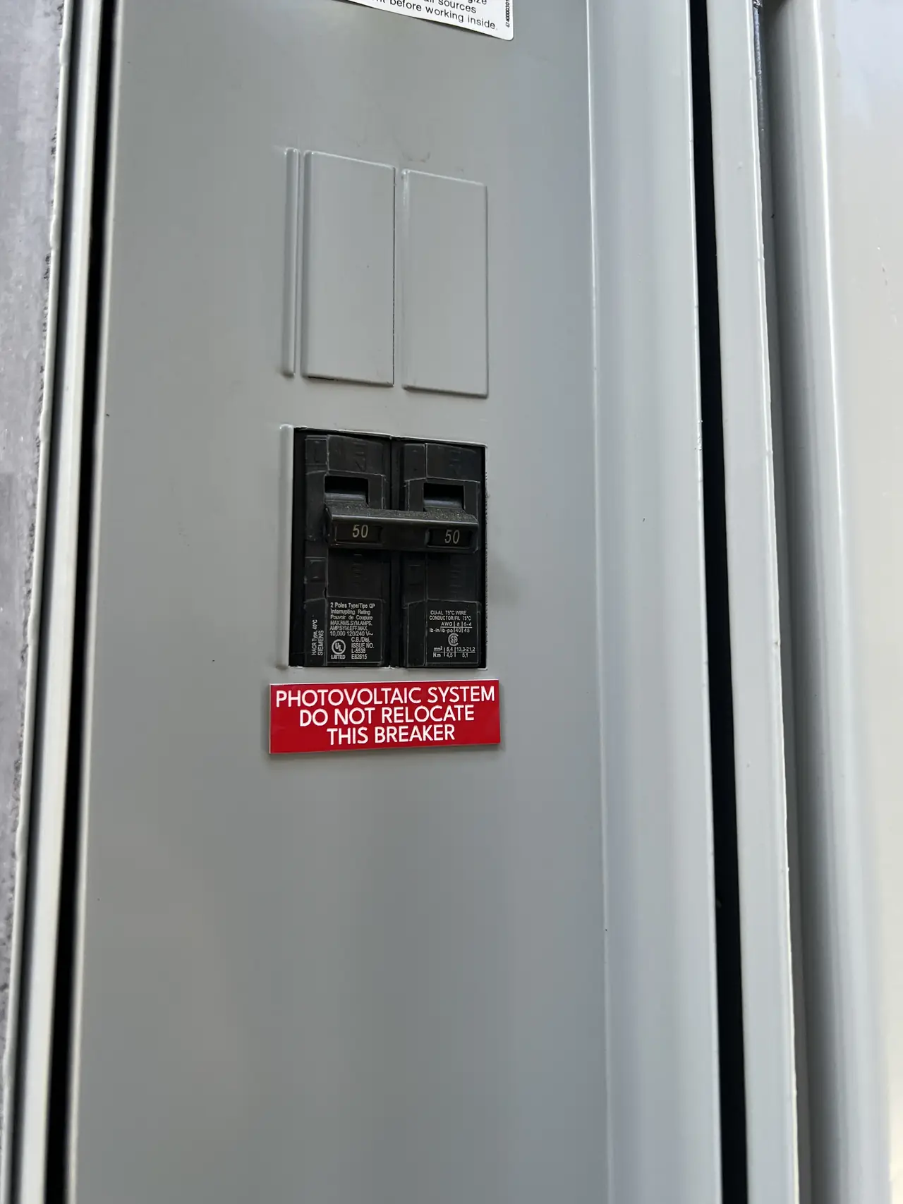 Service panel in Burbank with a dedicated solar breaker and a red label reading do not relocate this breaker