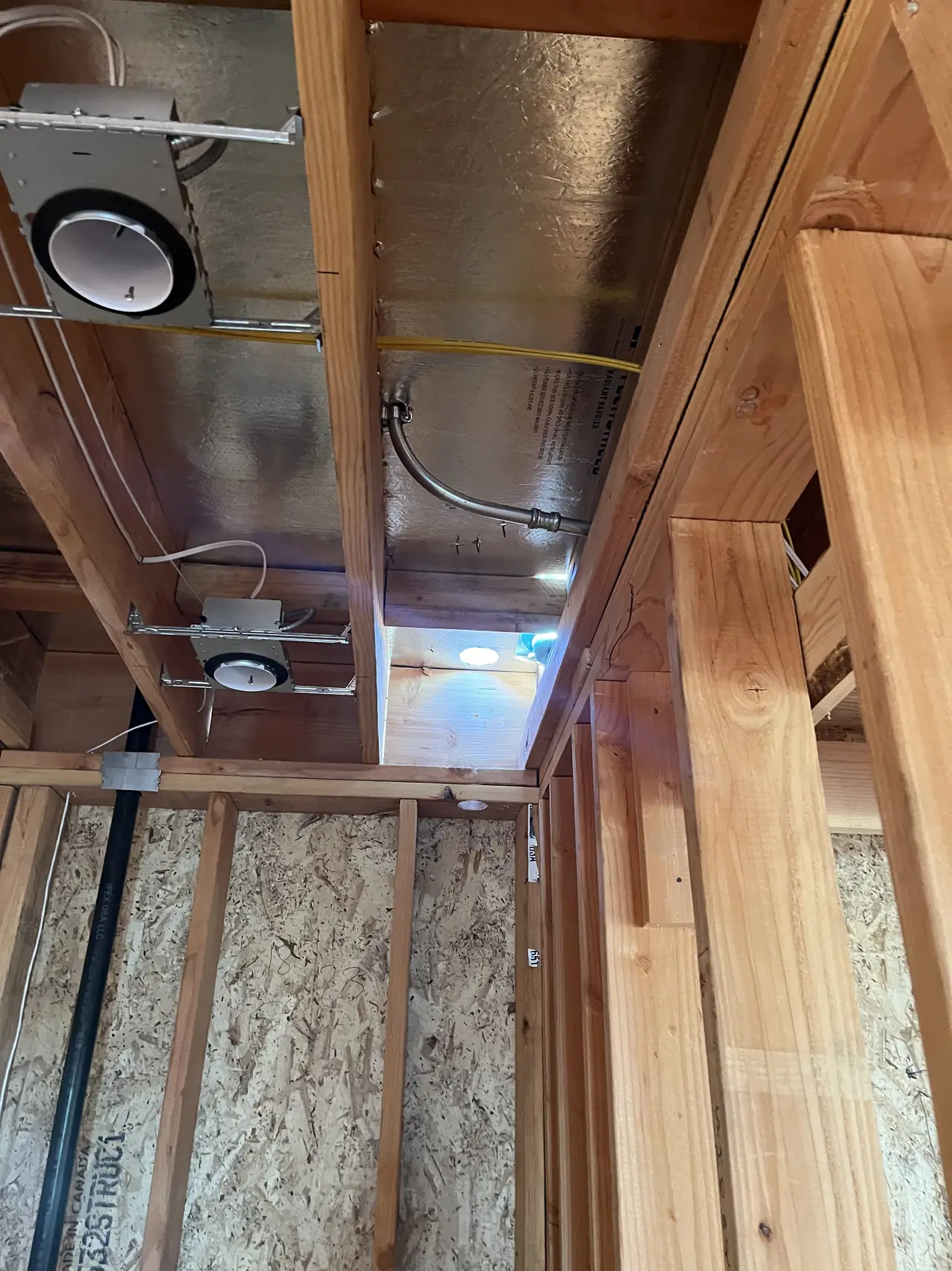 Conduit and a junction box running through open wood framing in a Burbank house before drywall