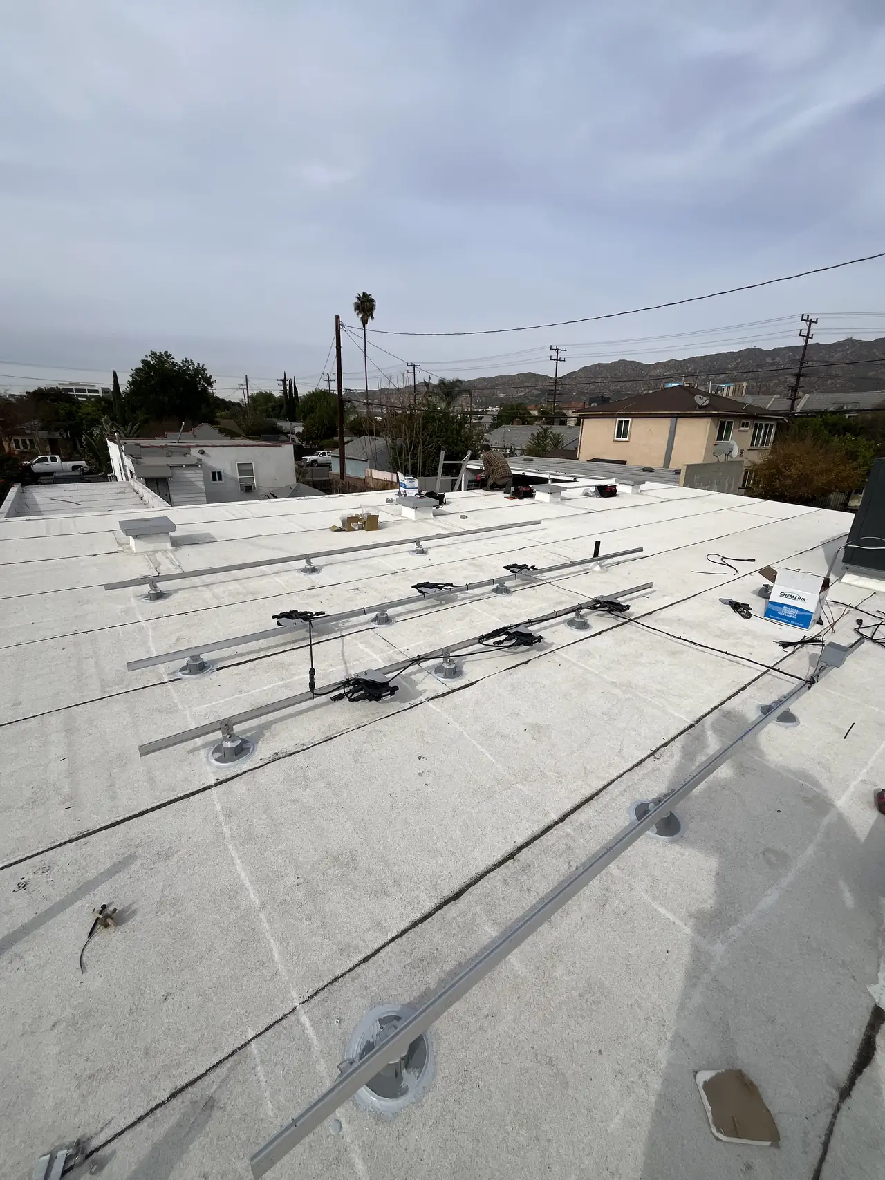 Mounting rails fixed to a flat roof in Burbank before the modules are set
