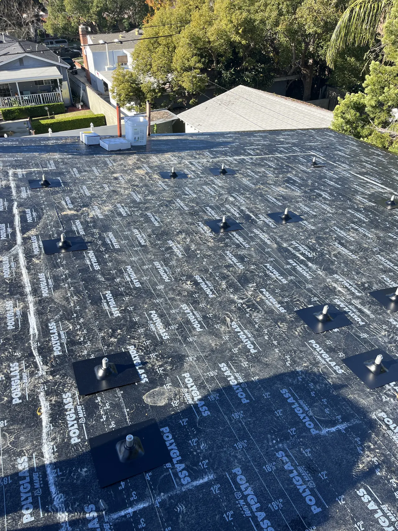 Roof underlayment on a new Burbank house with solar standoffs installed in a grid before the finished roofing