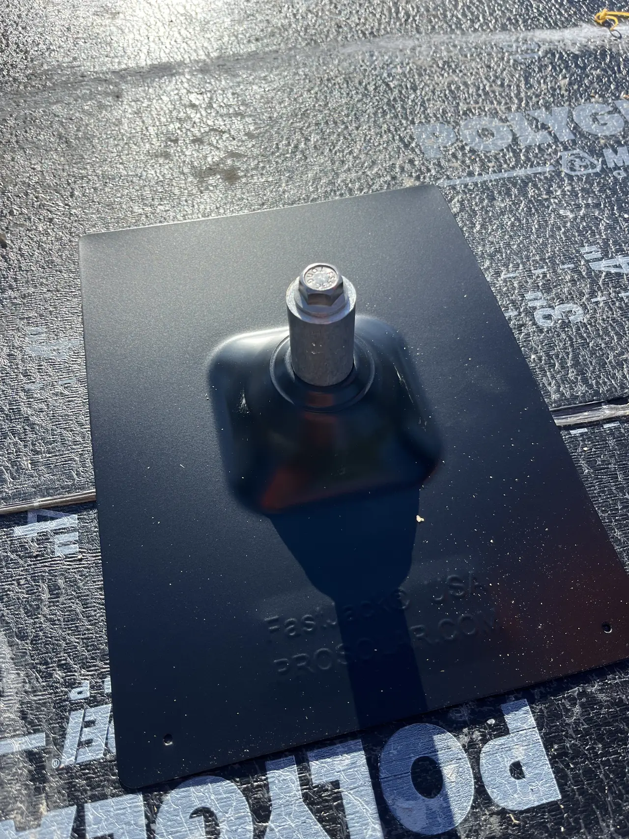 Close view of a single solar standoff on its metal mounting plate, set on roof underlayment in Burbank