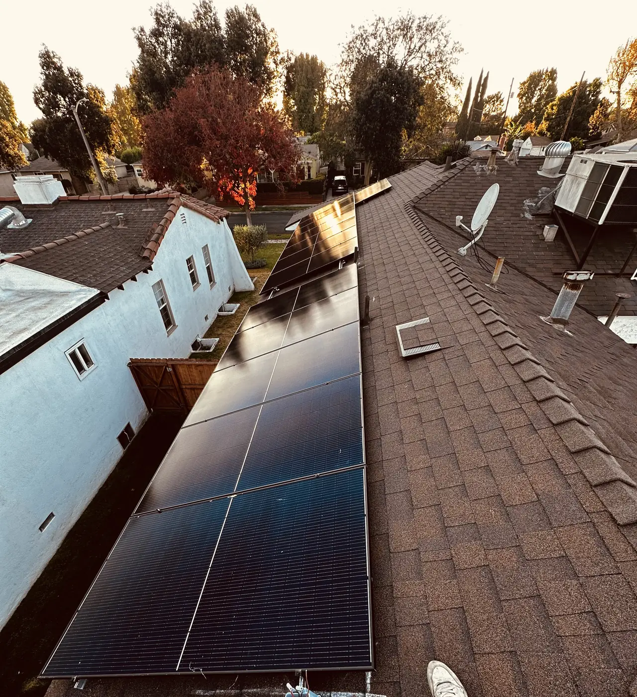Solar array running down a composition shingle roof toward the front garden of a Burbank house