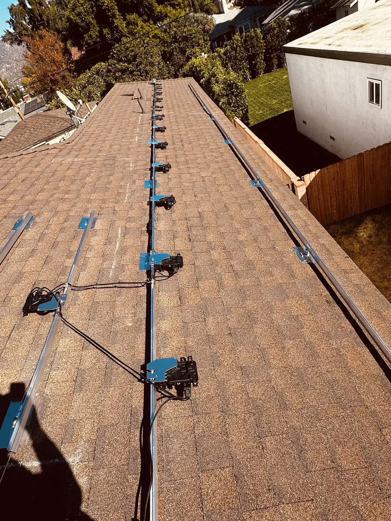 Mounting rails fixed across a shingle roof in Burbank with a microinverter mounted beneath