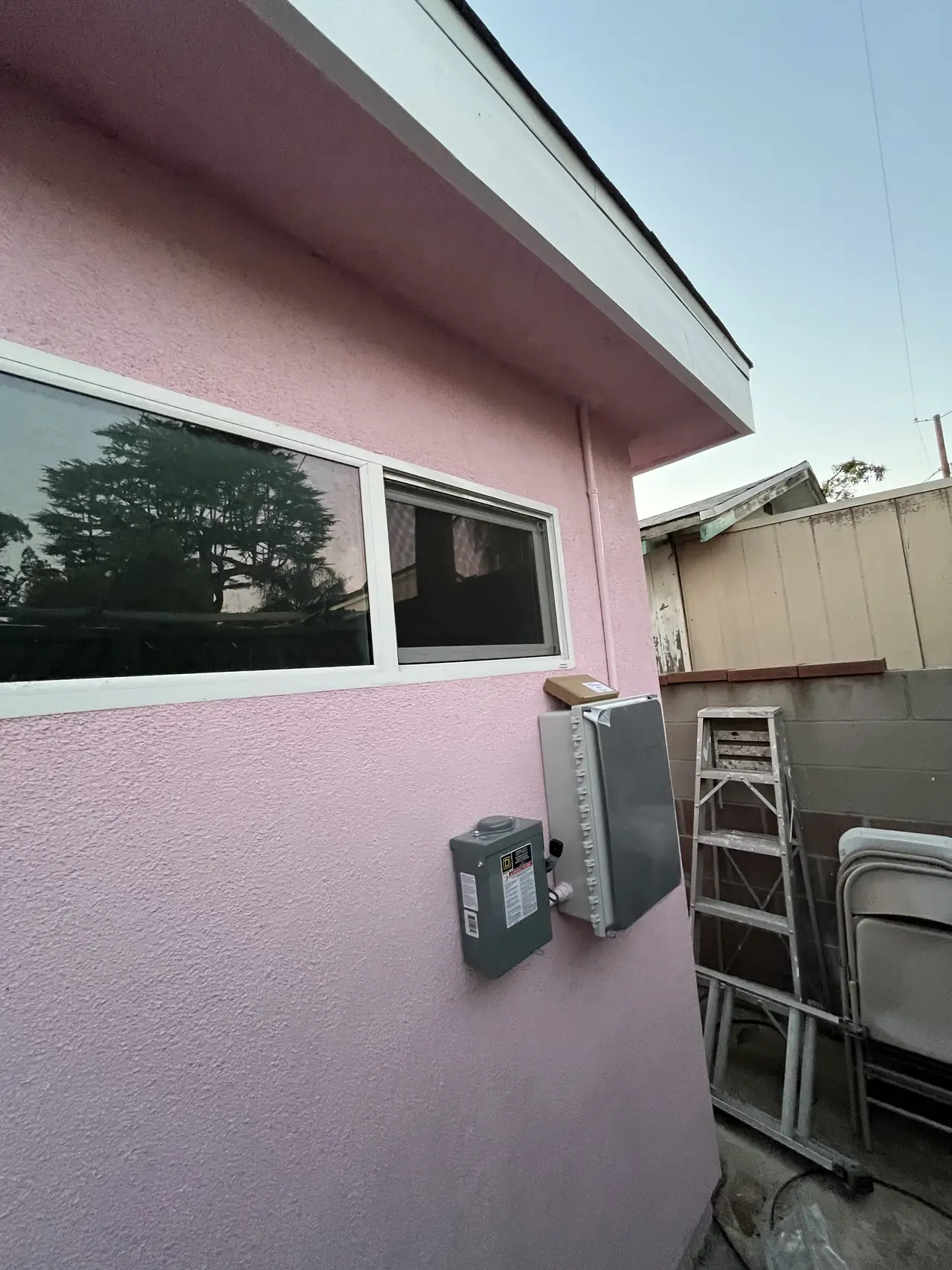 Combiner panel and electrical enclosures mounted on the exterior wall of a Burbank house