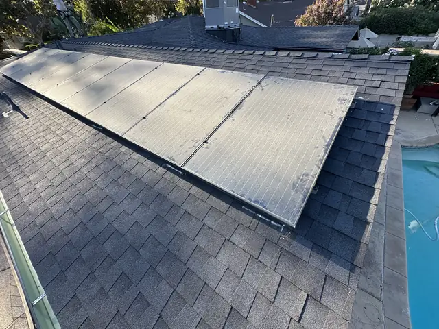 Solar array reinstalled on a newly shingled roof in Burbank with a swimming pool visible below