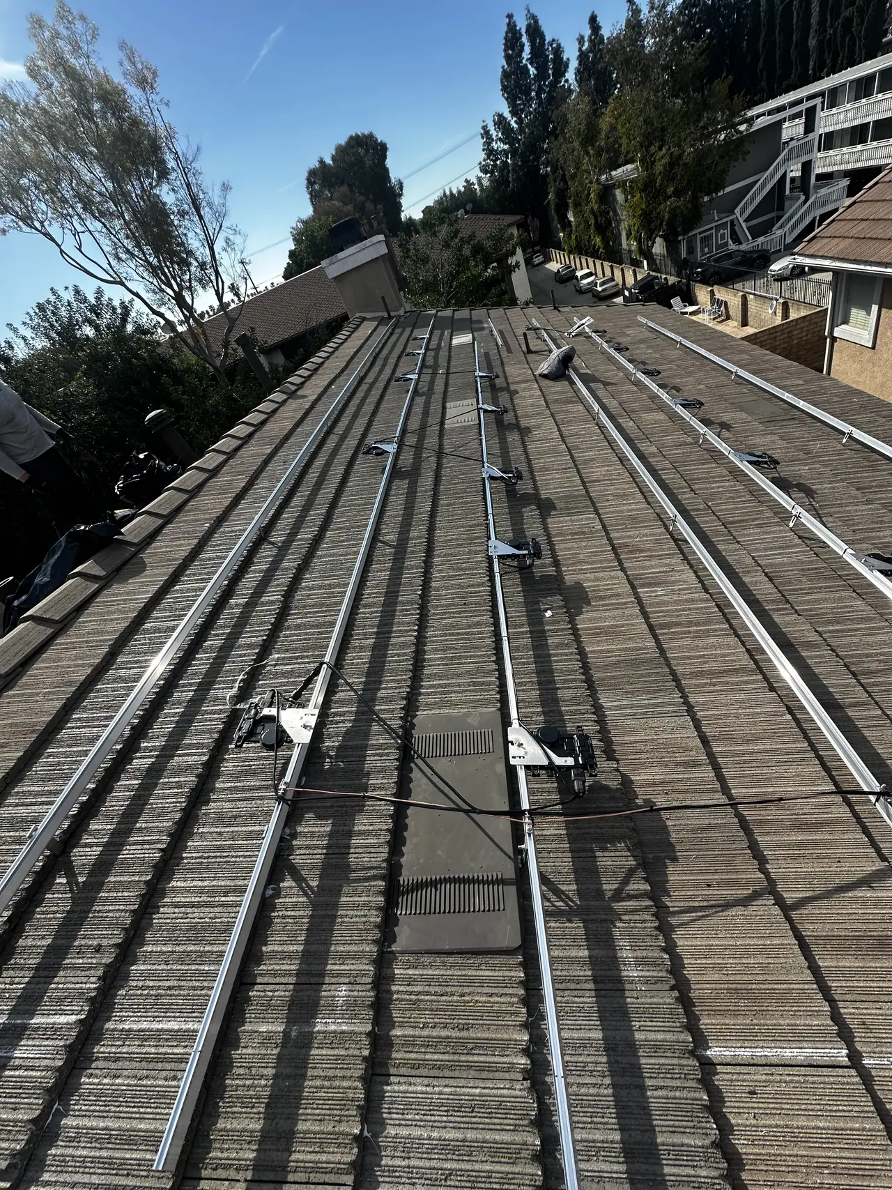 Mounting rails laid across a flat concrete tile roof before the modules go on, Canoga Park