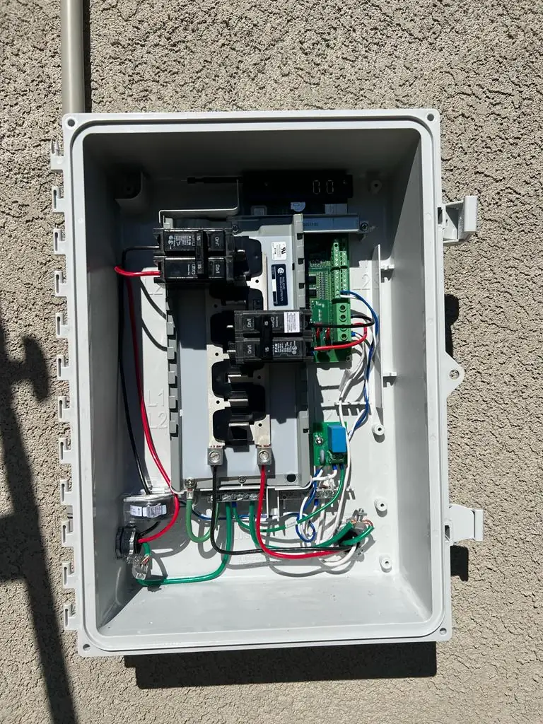 Enphase combiner enclosure opened to show breakers and wiring, Canoga Park