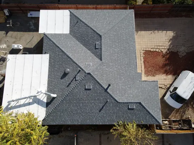 Aerial view of a finished composition shingle roof with two low-slope sections, Canoga Park