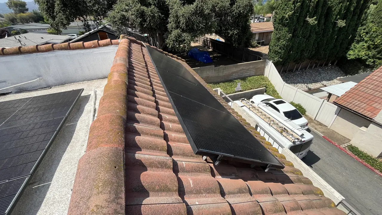 Solar panels on a barrel tile roof with an adjacent flat section in Covina