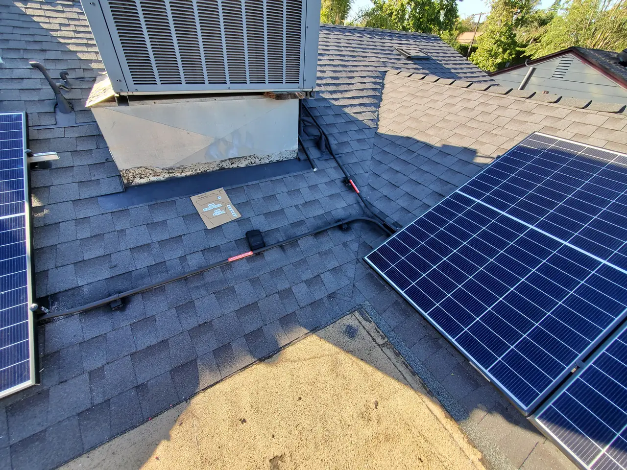 Solar modules on two planes of a new composition shingle roof, routed around a rooftop air conditioning unit, Encino