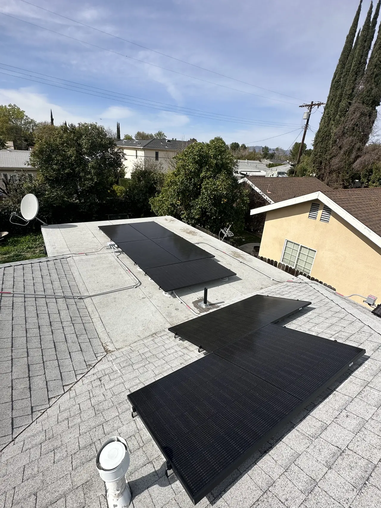 Solar modules across two planes of a shingle roof with conduit running along the ridge, Encino