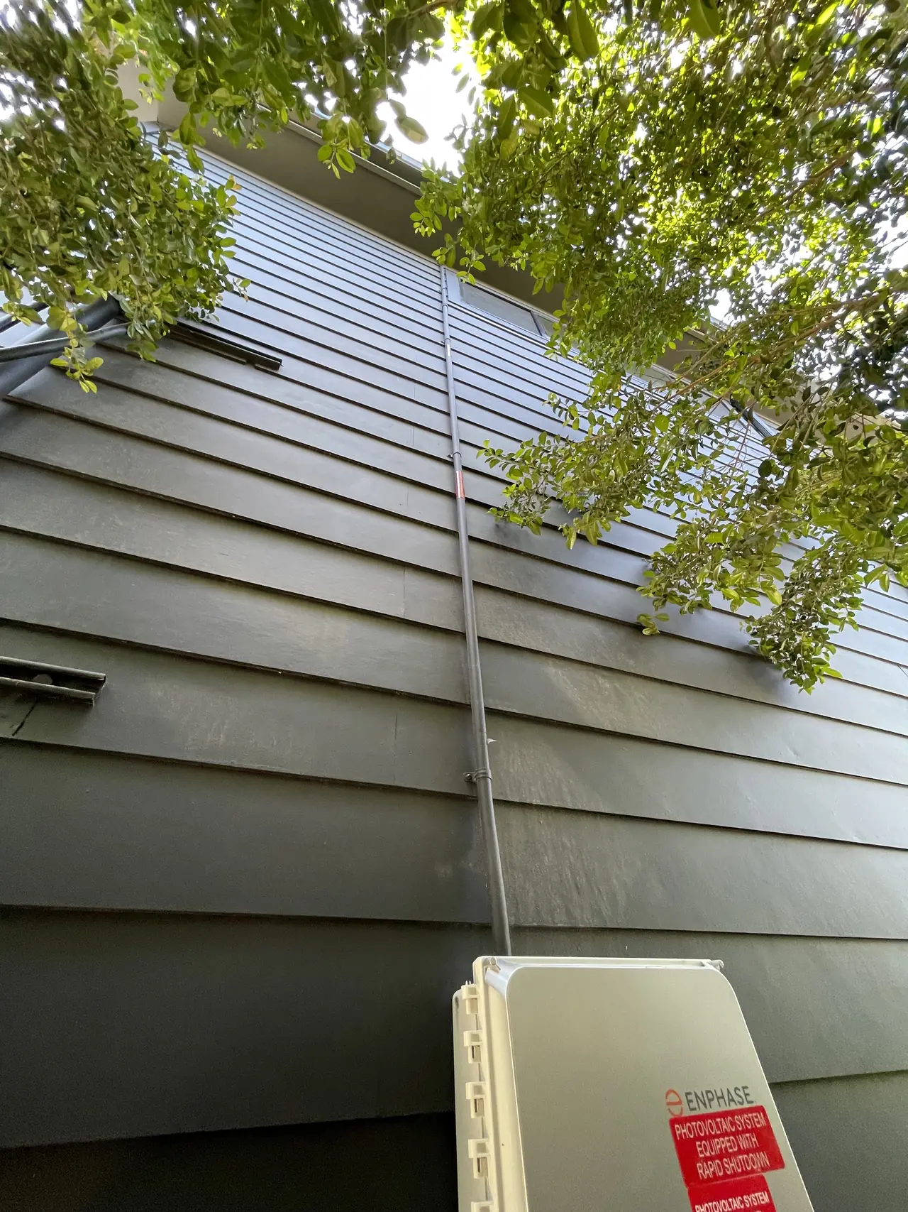 Conduit running down the siding of a new house from the roof to the combiner and service equipment
