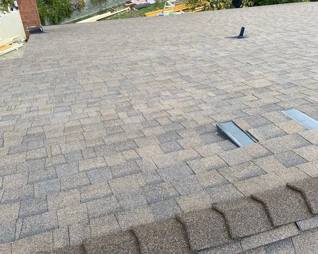 New composition shingle roof with ridge vents and hills beyond, Glendale