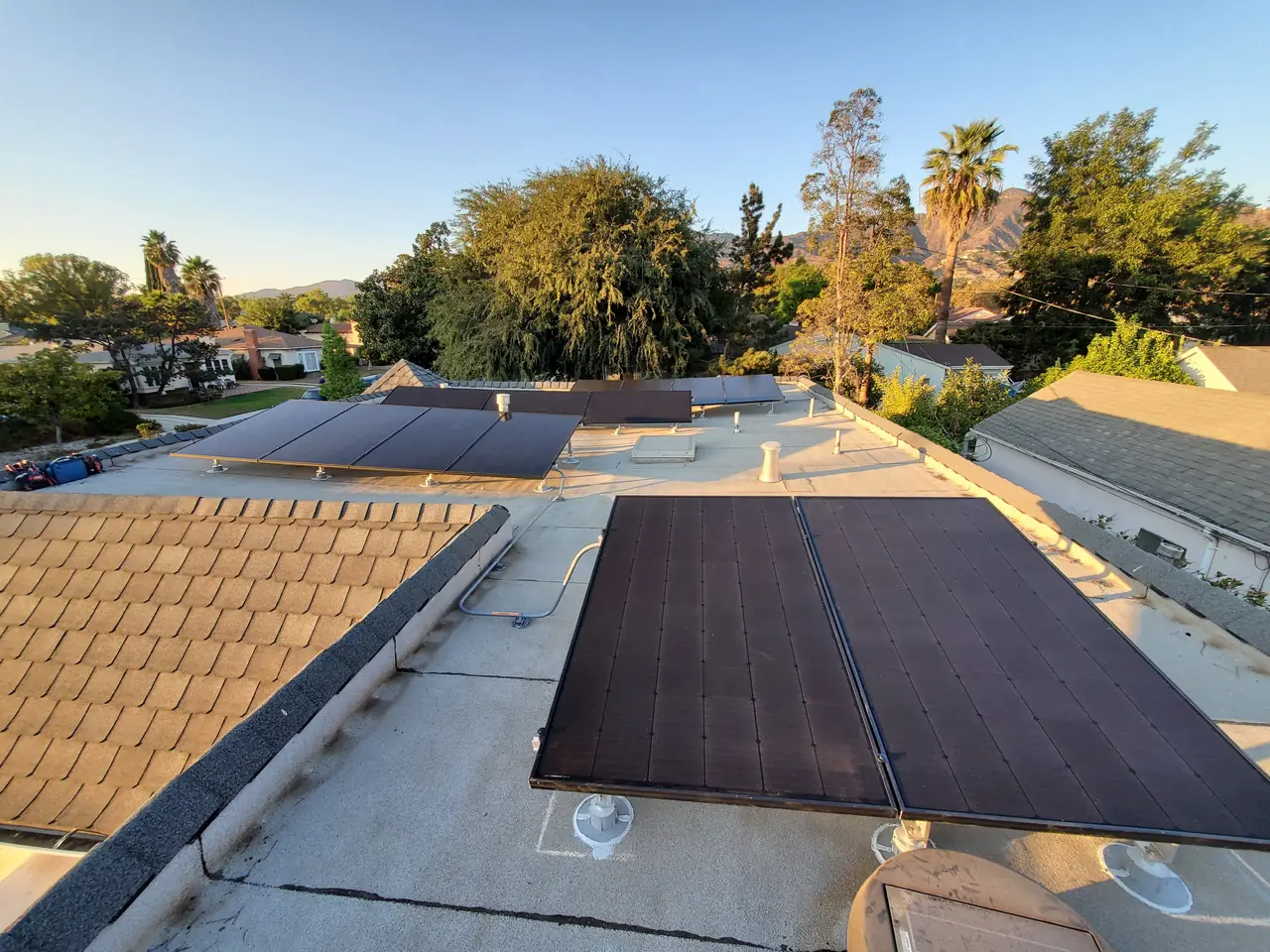Black solar modules on tilt frames over a flat built-up roof, Glendale