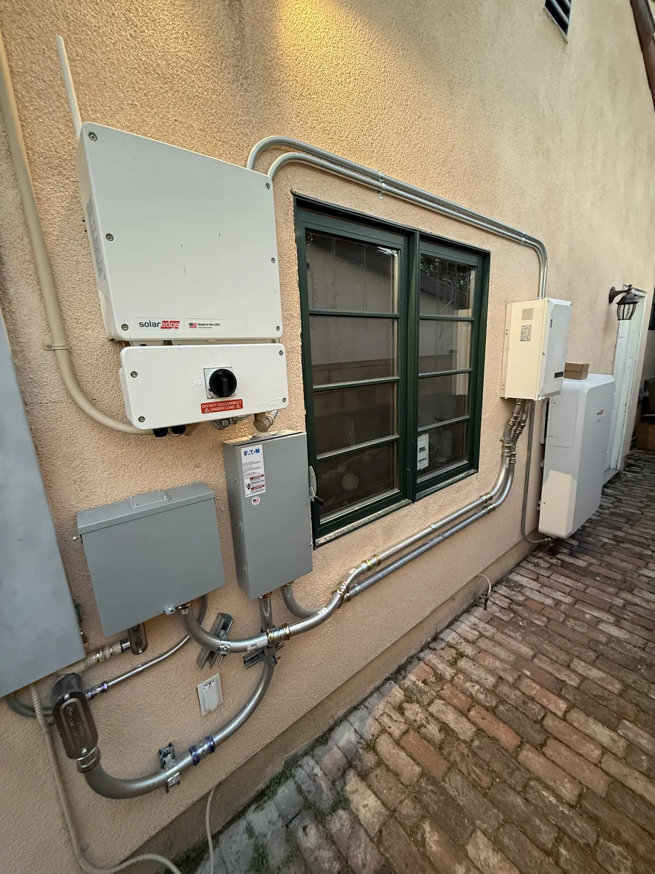 Side wall with the solar inverter, disconnects and conduit routed around a window frame, Glendale