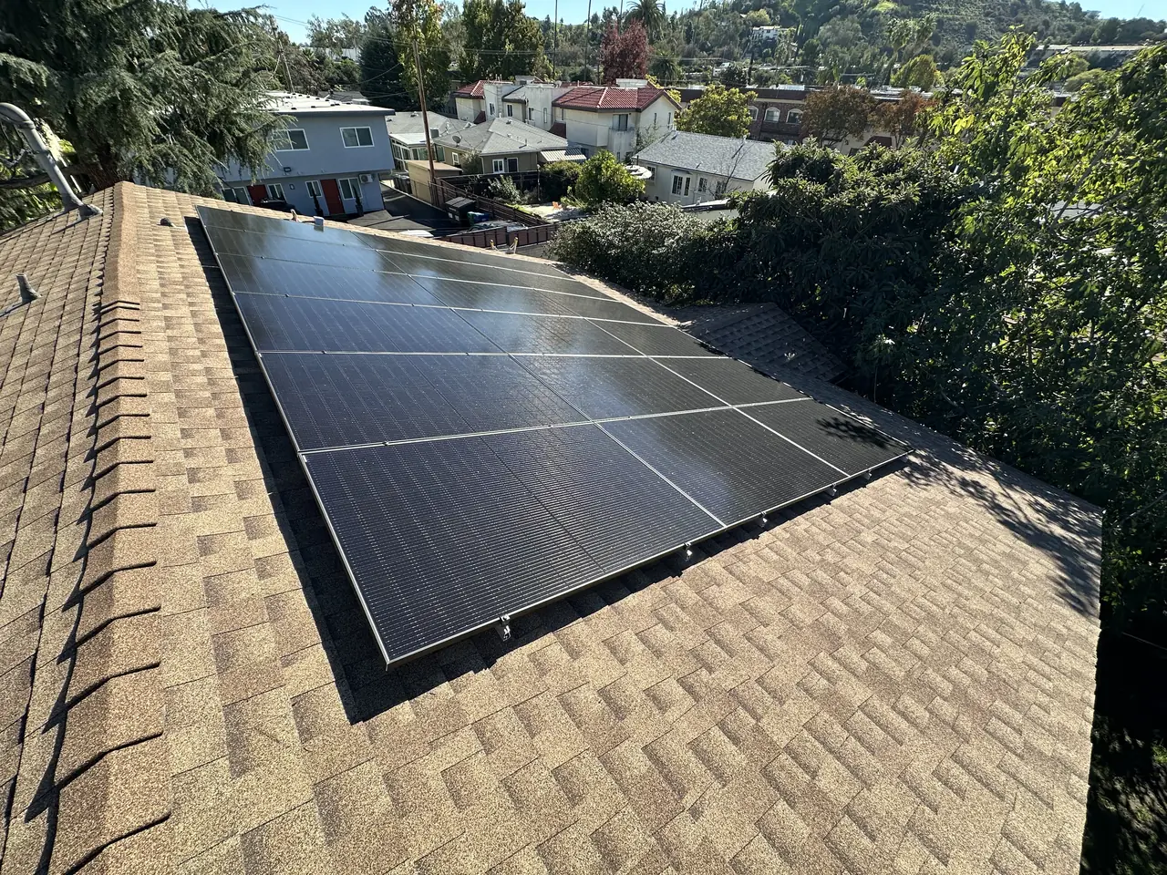Solar array on the shingle roof of the main house, looking across a hillside neighborhood, Glendale