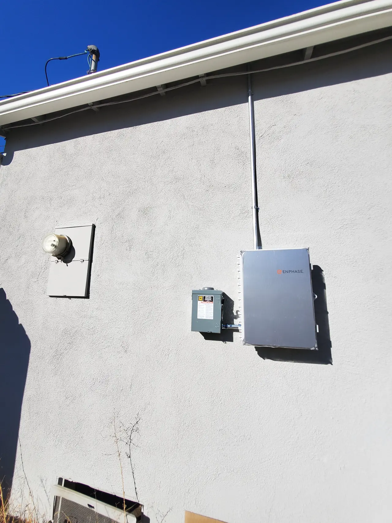 Side wall of a stucco house with a combiner, a disconnect and a blanked plate where the old meter was, Glendale