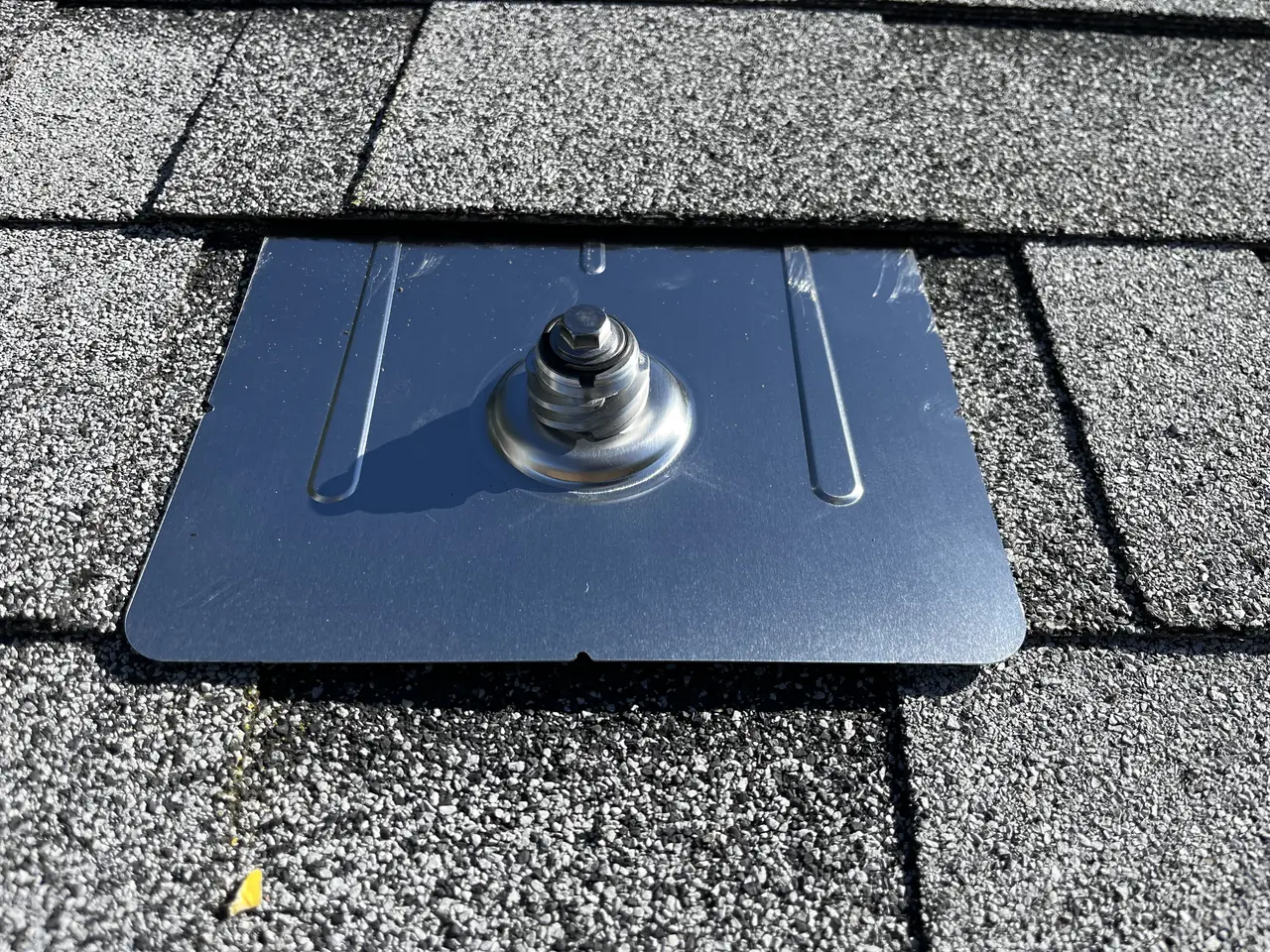 Close view of a flashed mounting foot set into a composition shingle roof, Glendale