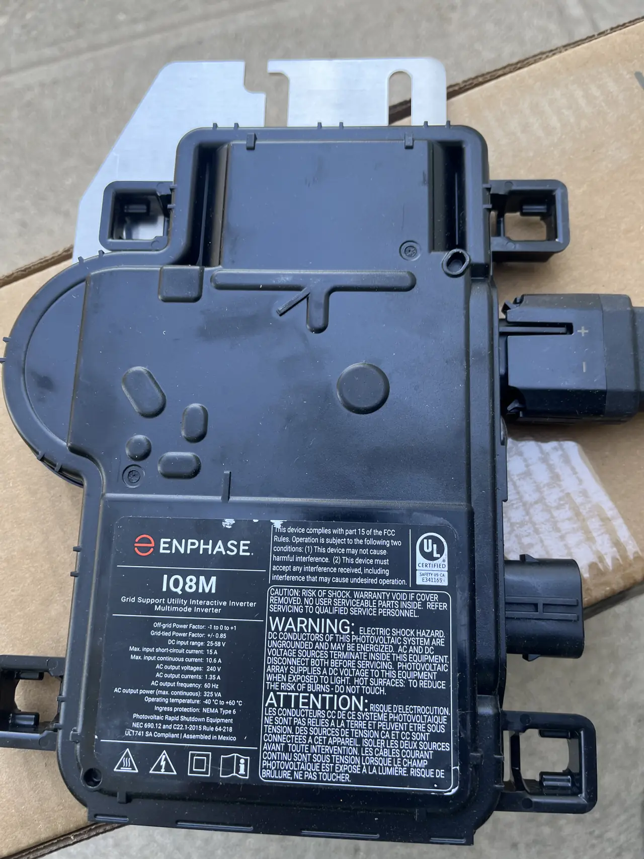 Enphase microinverter unit before installation under a module