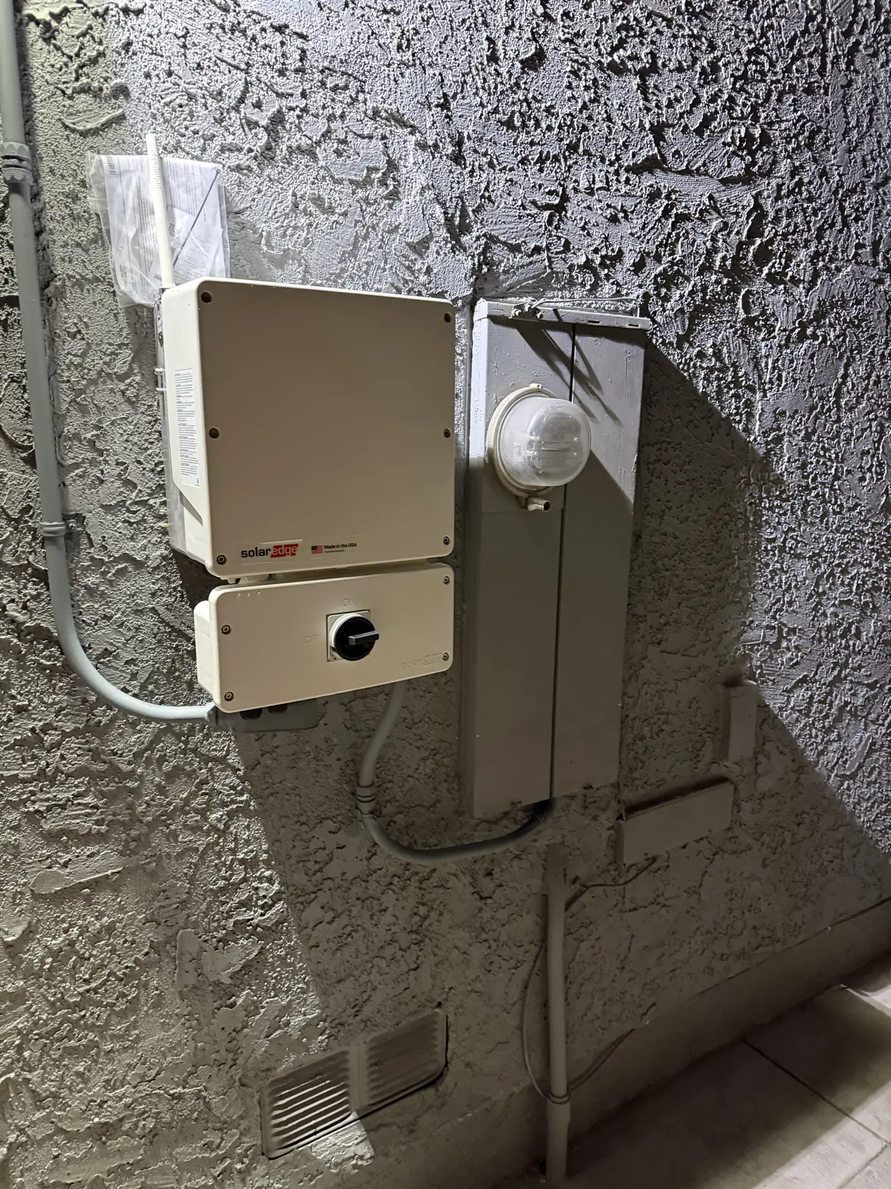 A string inverter and its DC disconnect mounted on a stucco wall, Granada Hills