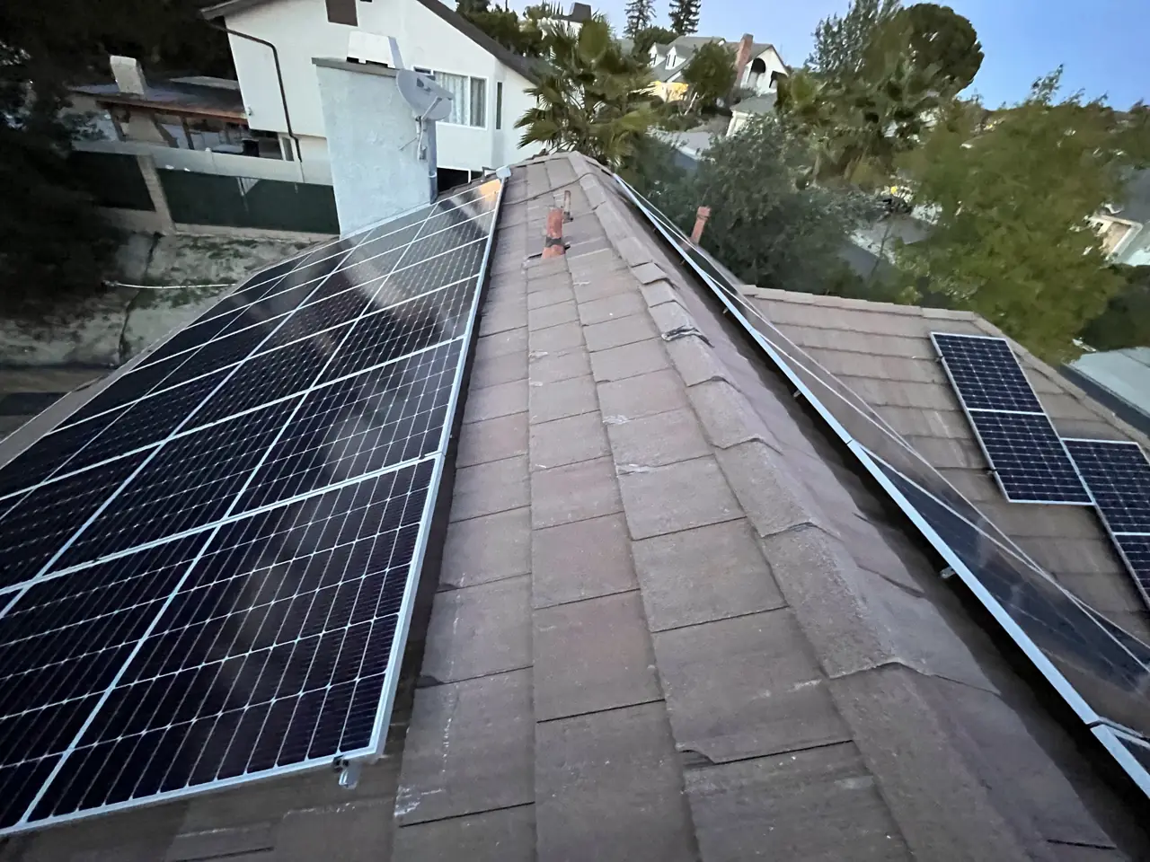 Solar modules set along both sides of a tile roof ridge with the valley beyond, Granada Hills