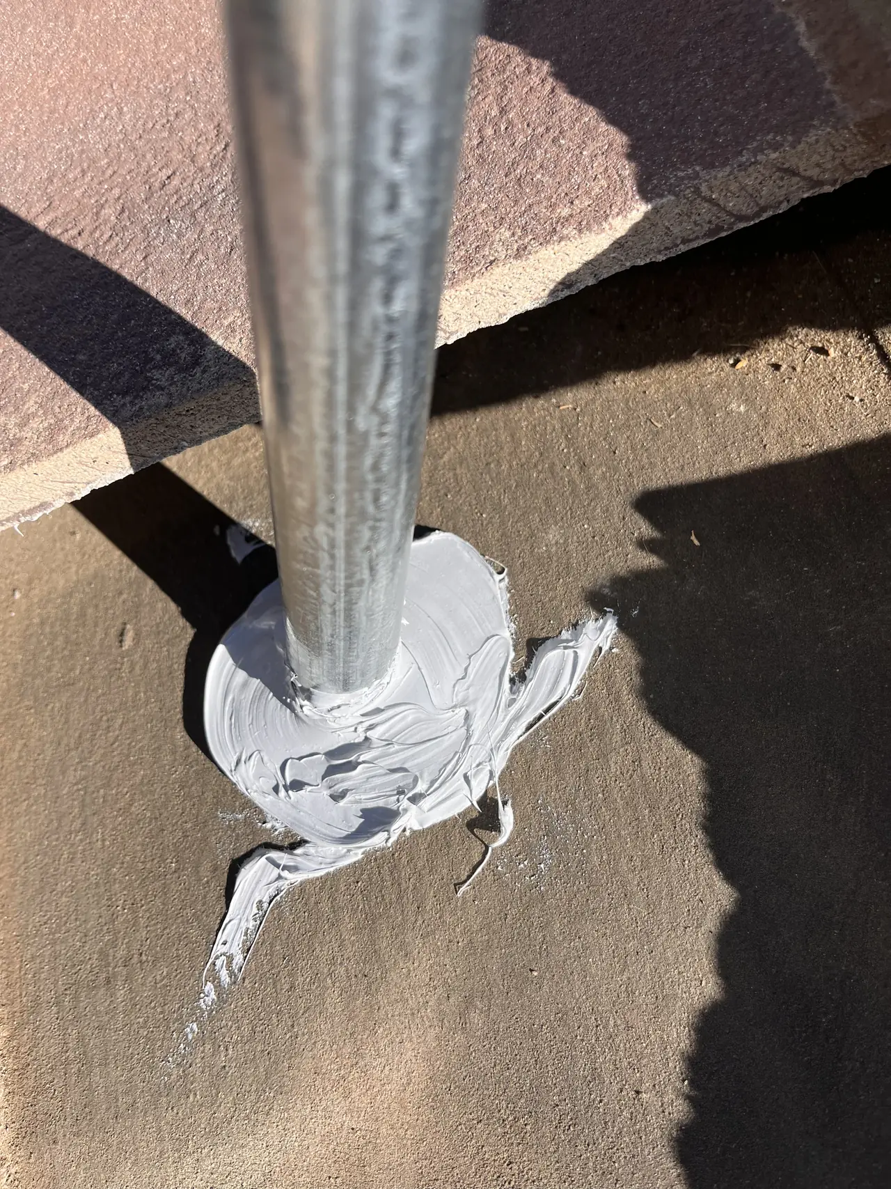 A conduit penetration through a concrete tile roof sealed with mastic, Granada Hills