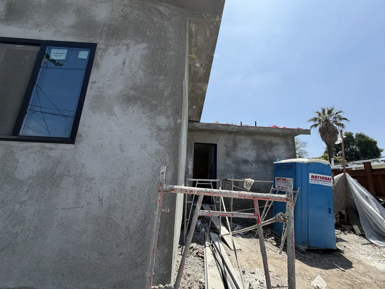 The end wall of a newly built unit in bare stucco with scaffolding, Granada Hills