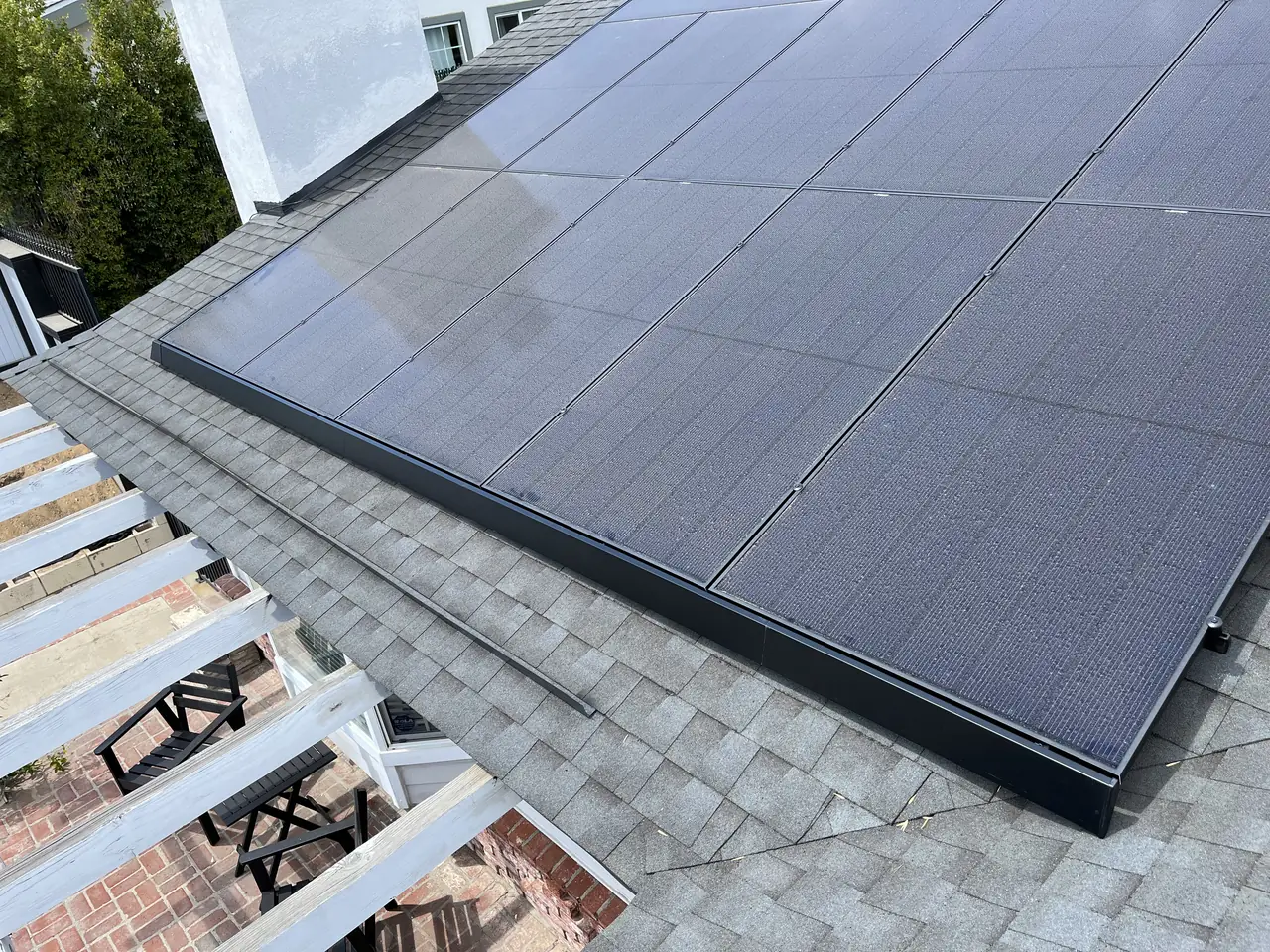 The lower edge of a solar array meeting the shingle course on a roof, Granada Hills