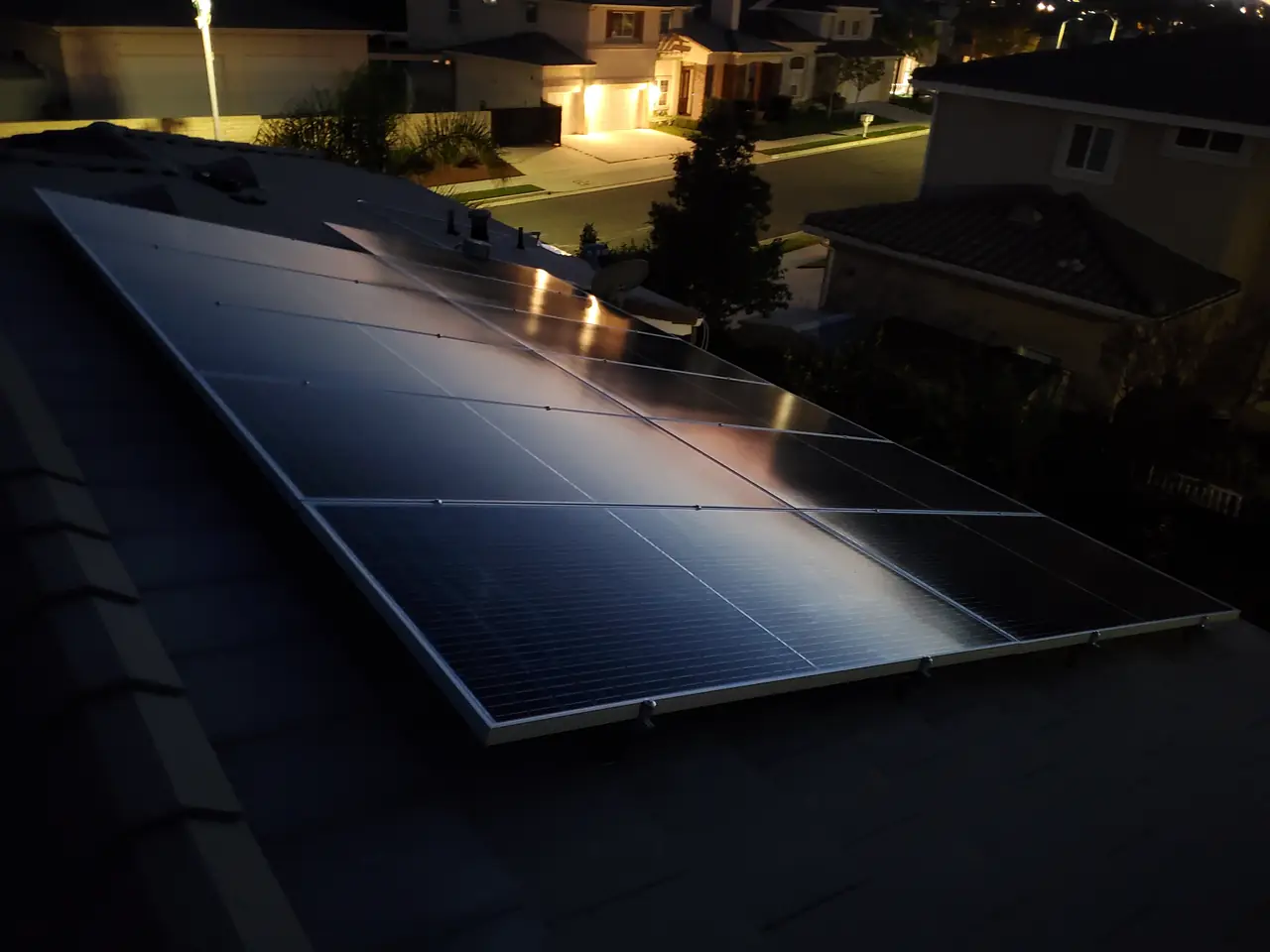 A black solar array across a concrete tile roof in the evening, Granada Hills