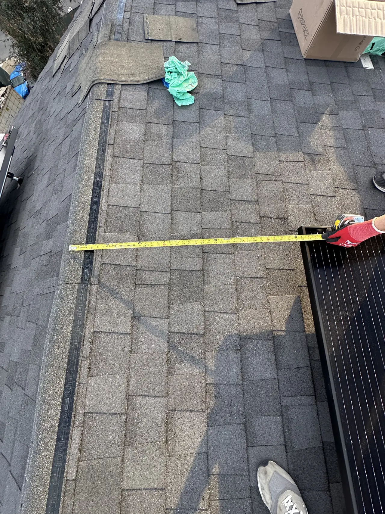 A tape measure stretched from the edge of a solar array to the ridge of a shingle roof, Hidden Hills
