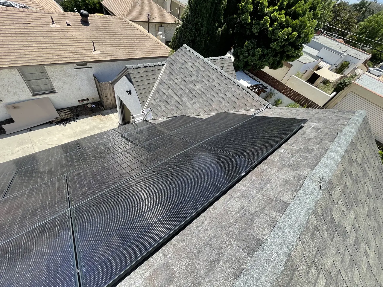 A solar array split into two groups on either side of a roof ridge, seen along the ridge line, Long Beach
