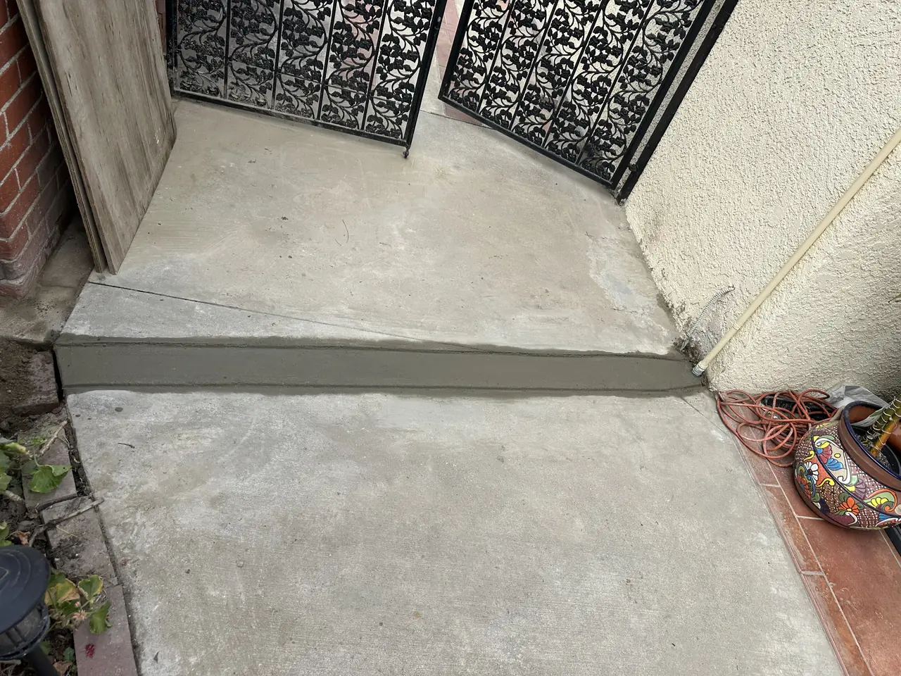 A concrete walkway with a fresh patch across it where a conduit run was laid underneath, Long Beach