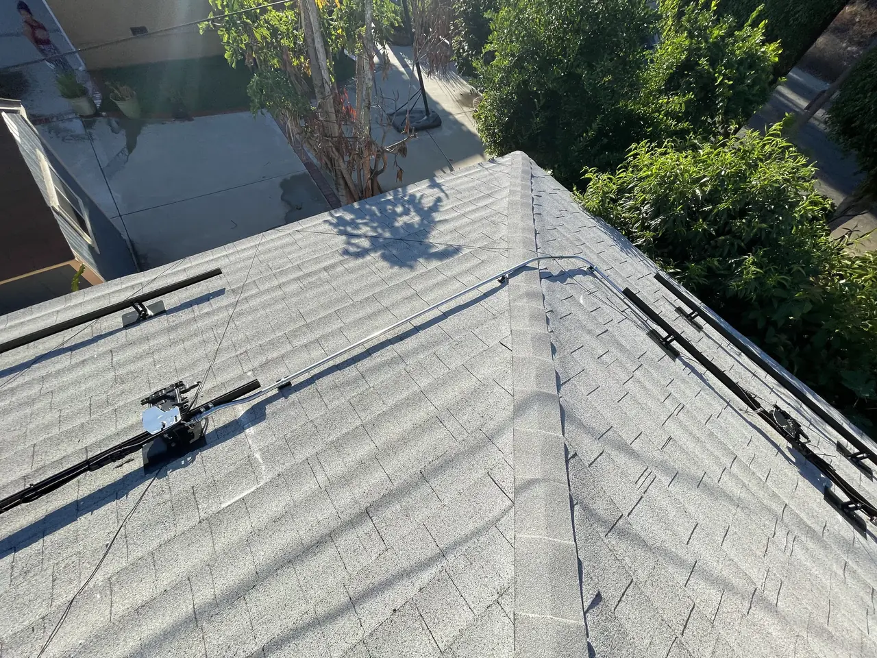 Aluminum rails and mounting hardware installed along the ridge of a shingle hip roof, Long Beach
