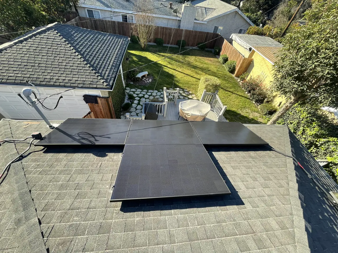 A solar array in two groups across a shingle roof above a driveway, Long Beach