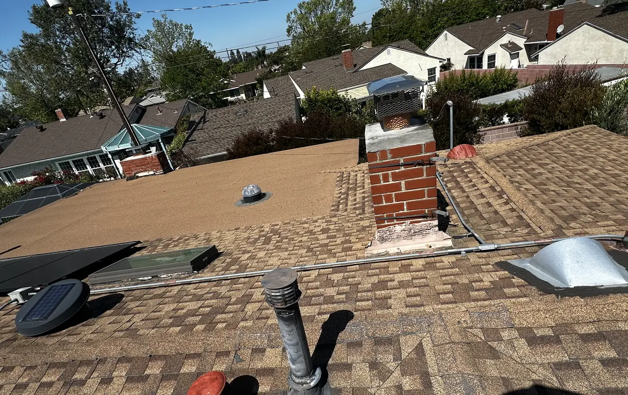 A solar array on a hip roof seen along the ridge with skylights and a vent left clear, Long Beach