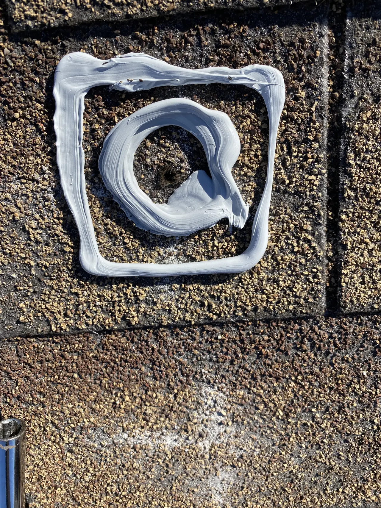 A roof penetration bedded in a thick ring of white sealant before the mount goes over it, Long Beach