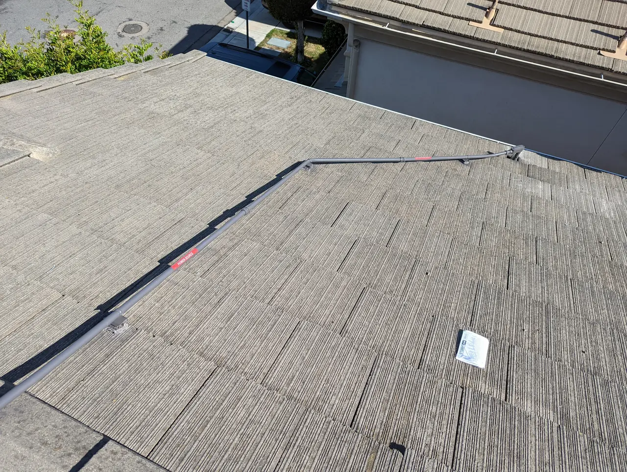 A labeled conduit run crossing a concrete tile roof away from the array, Long Beach