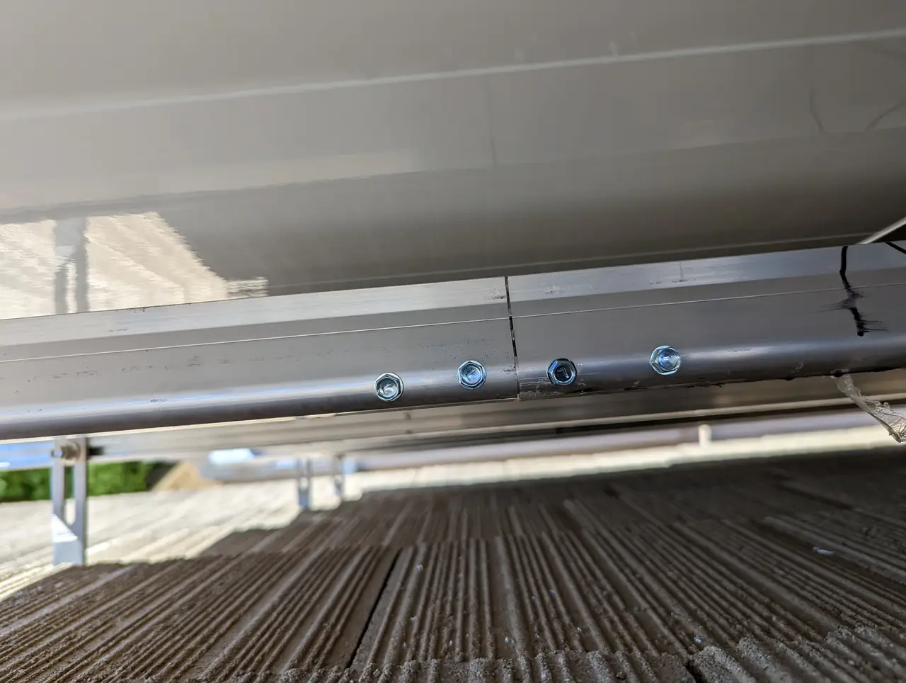 A conduit run and rail seen from beneath the array above the tile roof, Long Beach