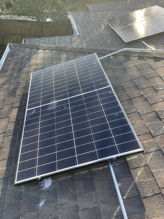 A single solar module mounted on a composition shingle roof with conduit running to it, El Sereno, Los Angeles