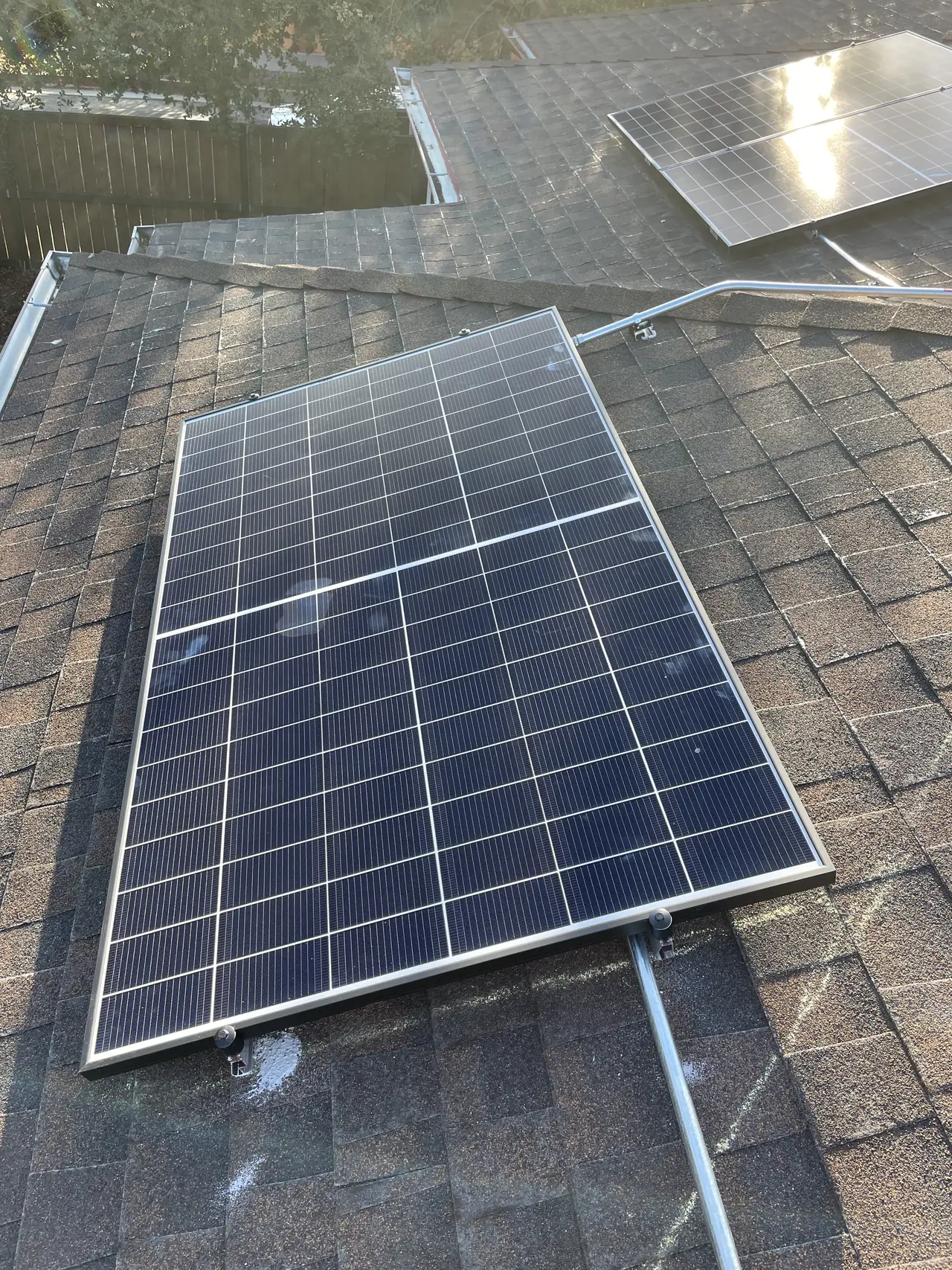 A single solar module mounted on a composition shingle roof with conduit running to it, El Sereno, Los Angeles