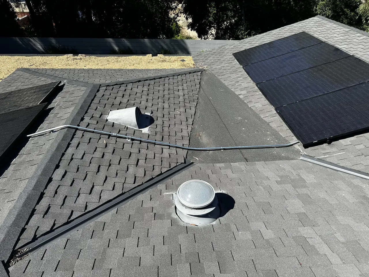 Two roof planes carrying solar modules with a conduit run between them, Brentwood, Los Angeles