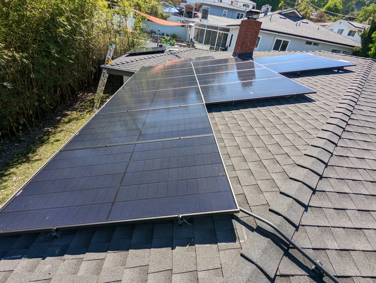 Two roof planes carrying solar modules with neighboring houses and hills beyond, Cypress Park, Los Angeles
