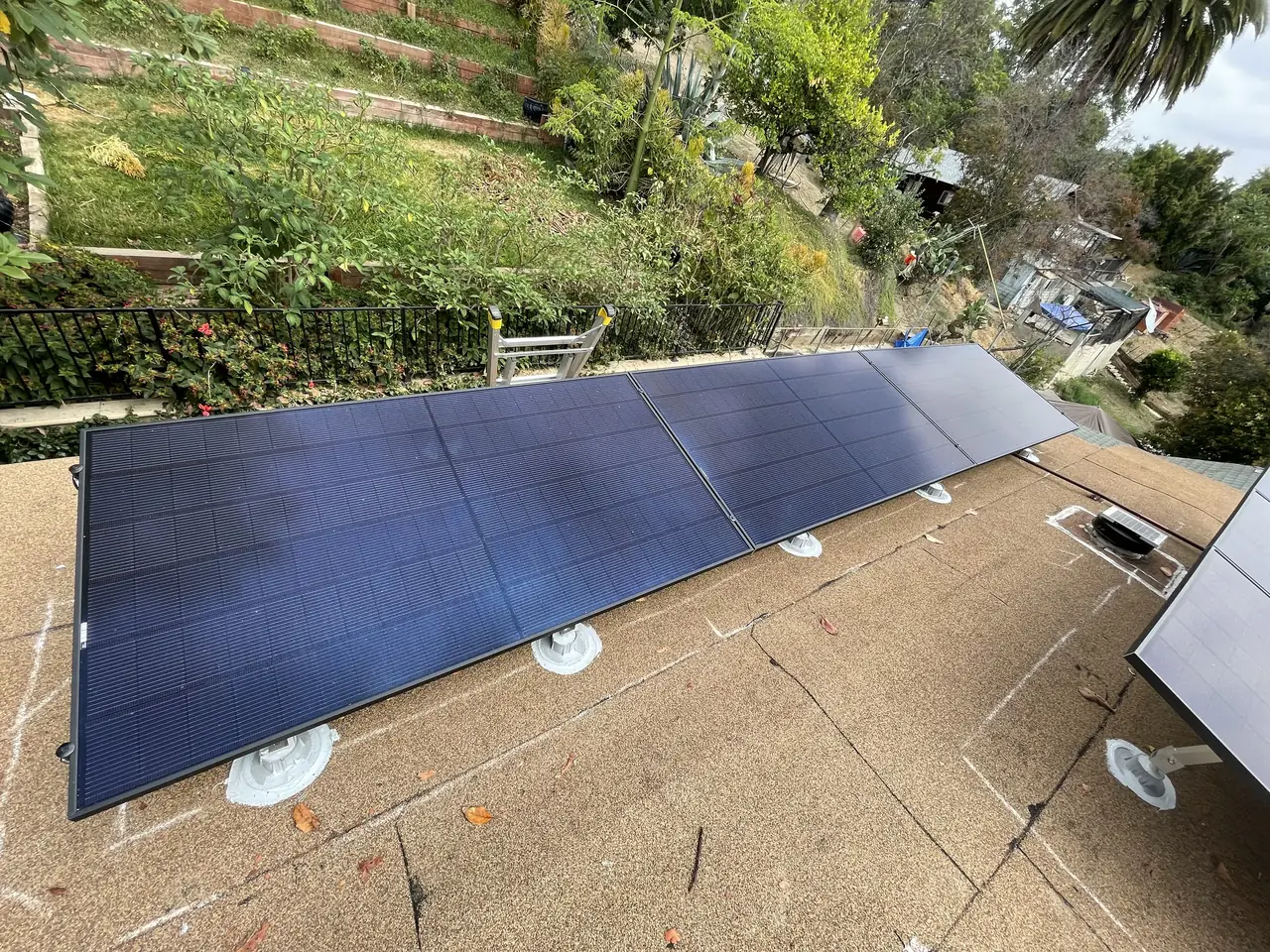 Solar modules mounted flush on a shingle slope above a terraced garden, El Sereno, Los Angeles