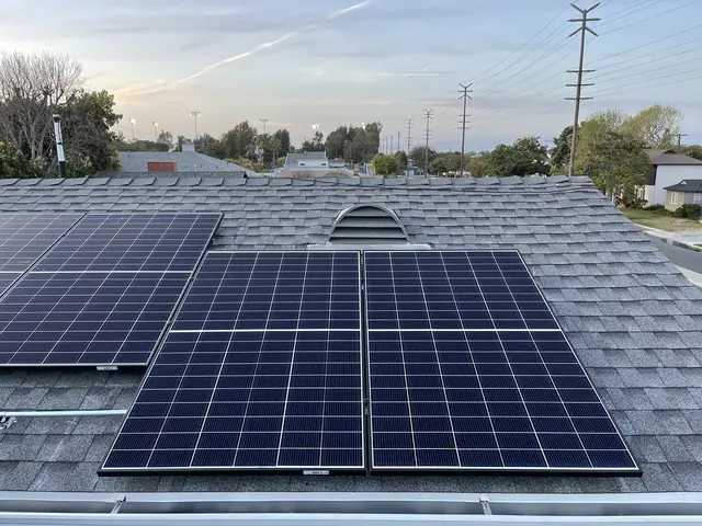 Solar modules on a composition shingle roof at dusk with a residential street beyond, Westchester, Los Angeles