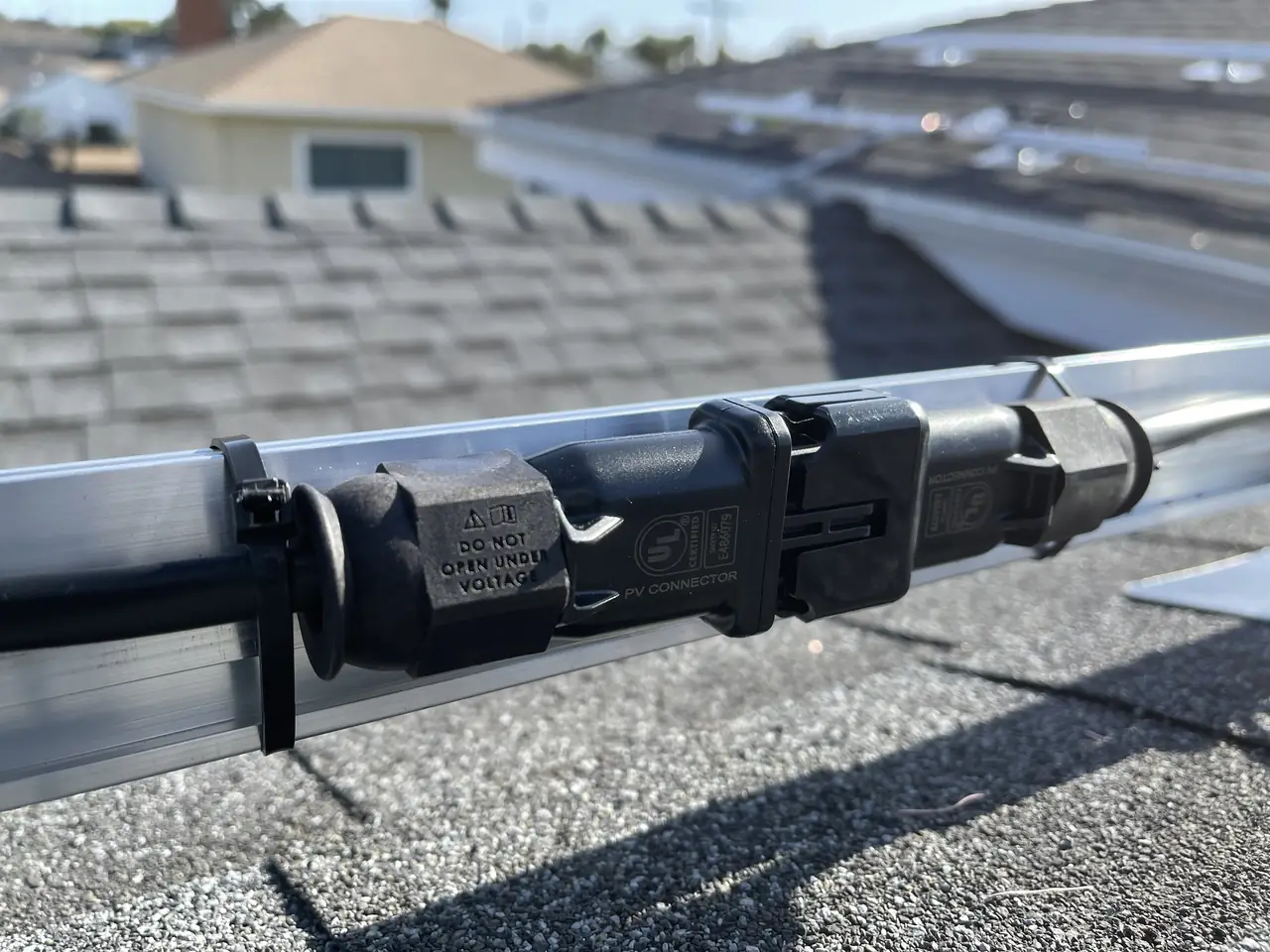 Mounting clamp and conduit running along a rail beneath a solar module, Westchester, Los Angeles