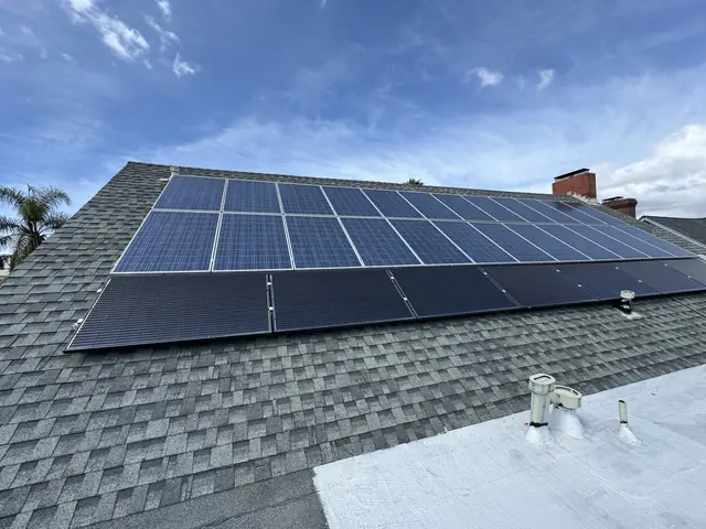 An existing rooftop solar array on a shingle roof under a clear sky, Windsor Square, Los Angeles