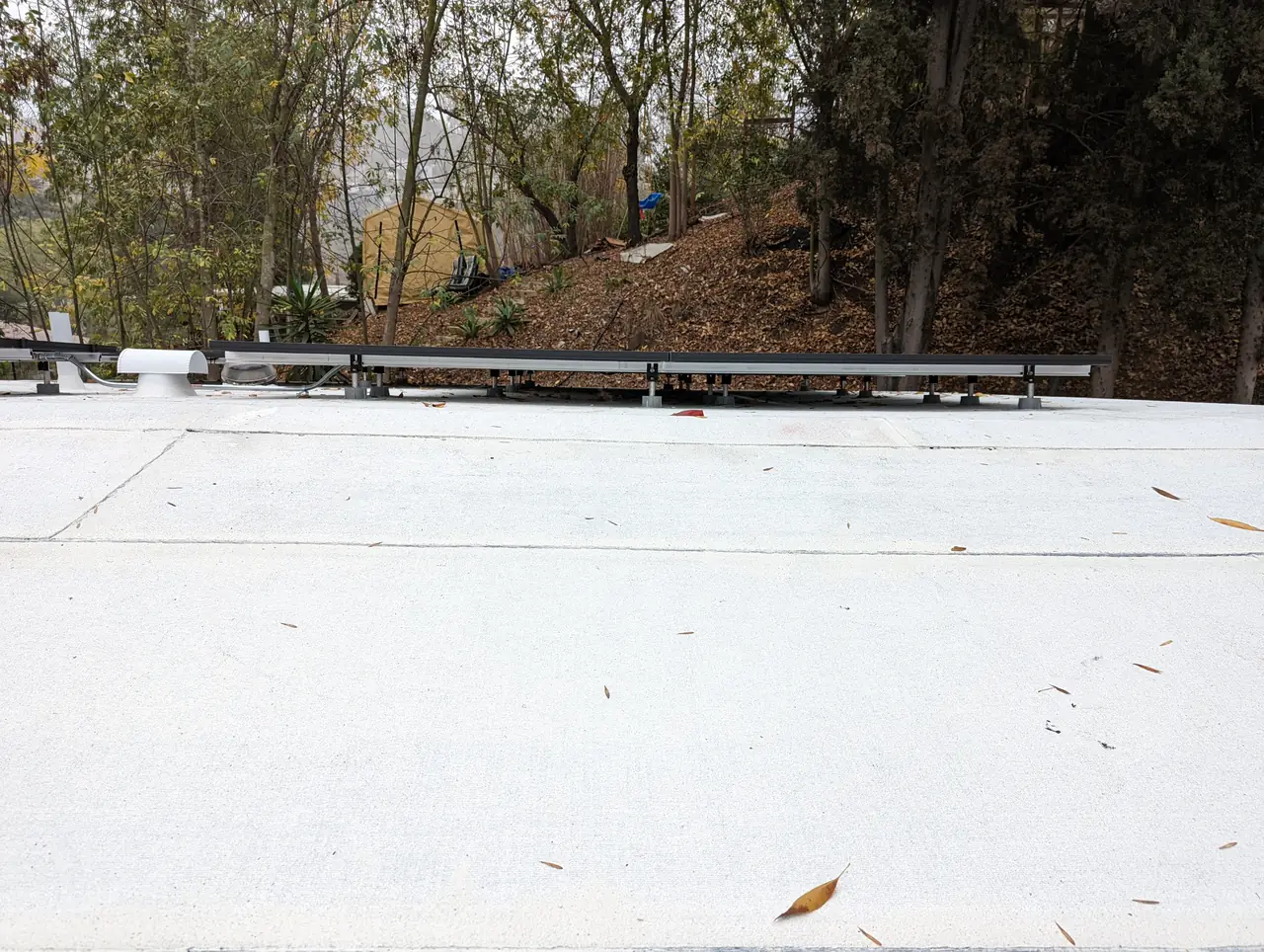 A newly finished white low-slope roof covering with mounting rails and no modules yet, Glassell Park, Los Angeles