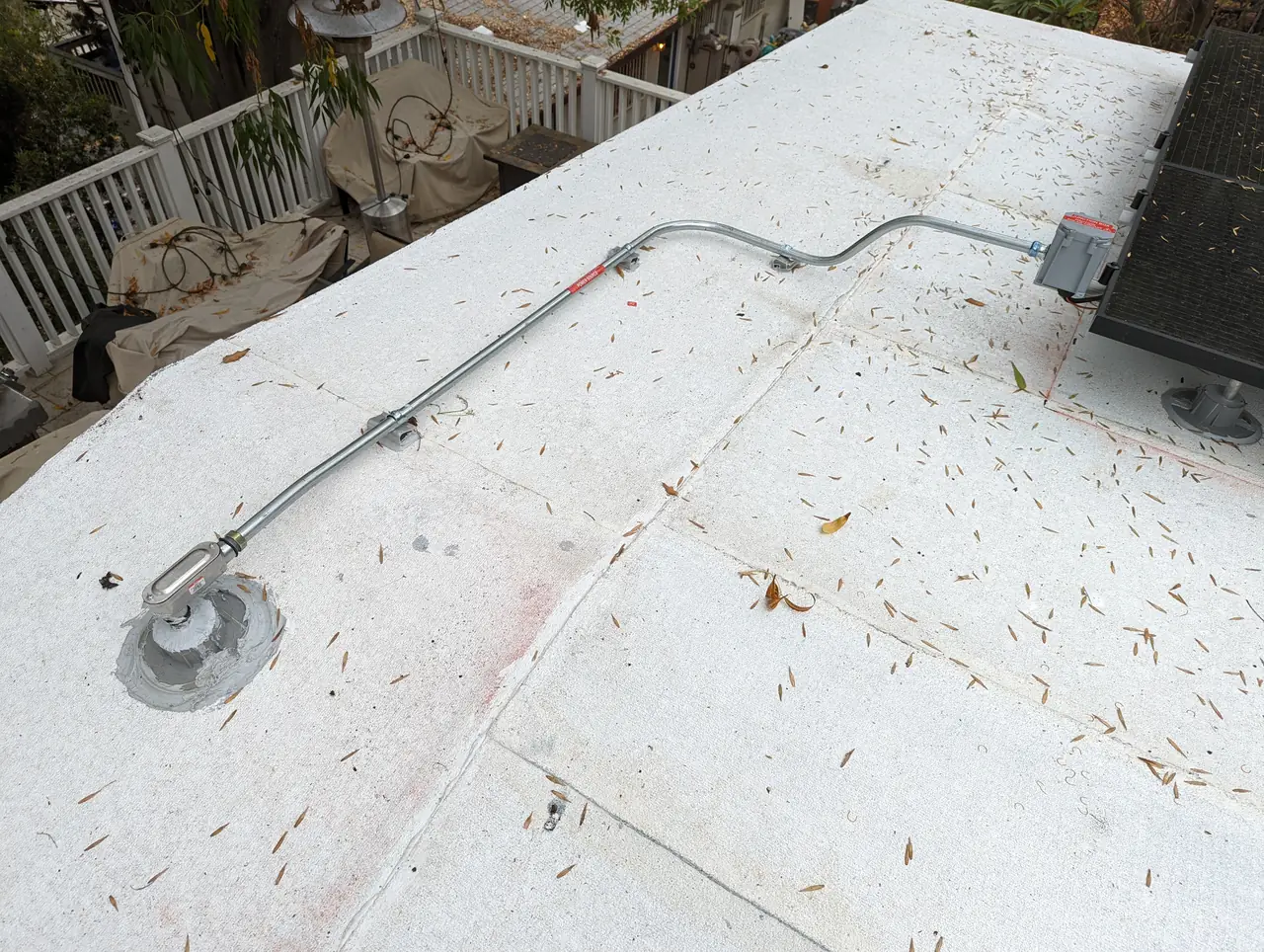 New roof covering with a drain and a conduit run beside the array, Glassell Park, Los Angeles